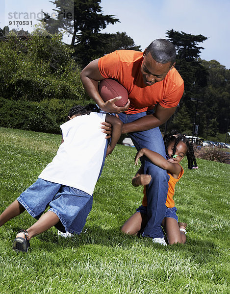 Father and children playing in park