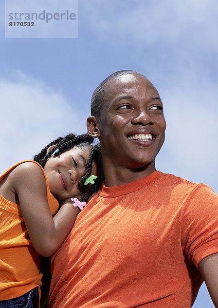 Father carrying daughter outdoors