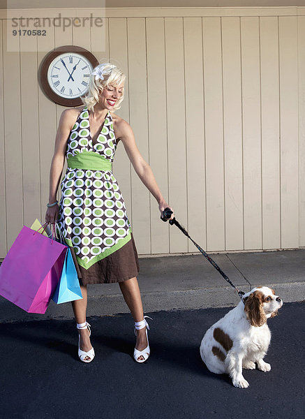 Caucasian woman with dog on sidewalk