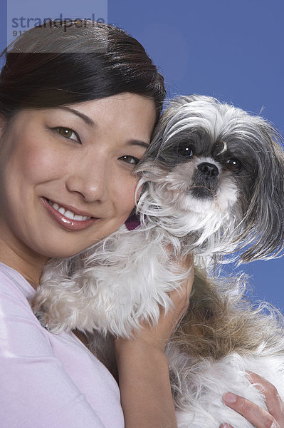 Chinese woman holding dog outdoors