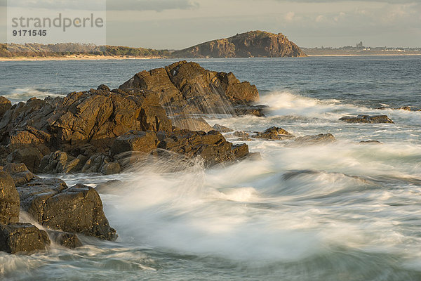 Australia  New South Wales  Tweed Shire  splashing breakwater at the rocky shore of Hastings Point in the first morning light
