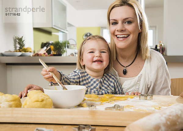 Porträt von Mutter und Tochter beim Backen in der Küche zu Hause