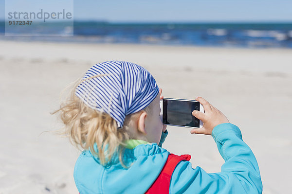 Deutschland  Mecklenburg-Vorpommern  Rügen  Schaabe  Junge mit Handy am Strand