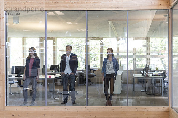 Team von drei Geschäftsleuten am Arbeitsplatz im modernen Büro