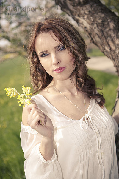 Porträt einer jungen Frau mit gelben Blumen