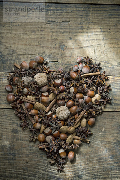 Herz aus Sternanis  Nüssen und Zimtstangen auf Holz