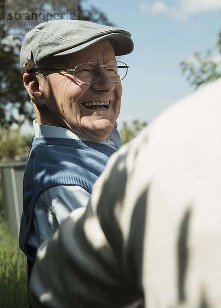 Porträt eines glücklichen alten Mannes mit Mütze