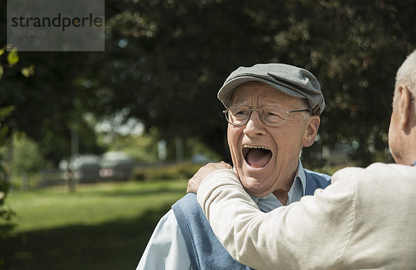 Portrait eines glücklichen alten Mannes  der sich mit seinem Freund amüsiert.