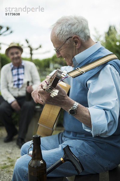 Zwei alte Männer mit Gitarre im Park