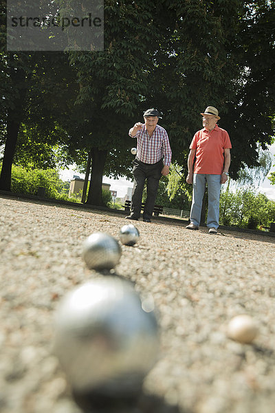 Zwei alte Freunde spielen Boule im Park.