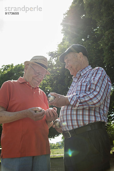 Zwei alte Freunde mit Boulebällen im Park