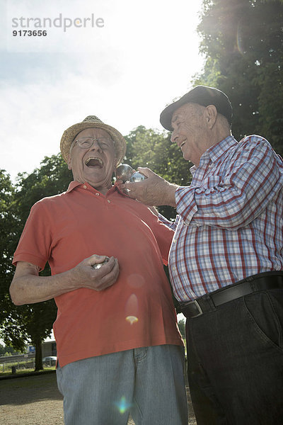 Zwei alte Freunde mit Boulebällen im Park