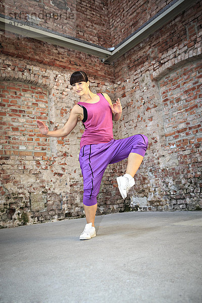 Frau im Sportkleid tanzt zumba oder Aerobic im Fitnessstudio