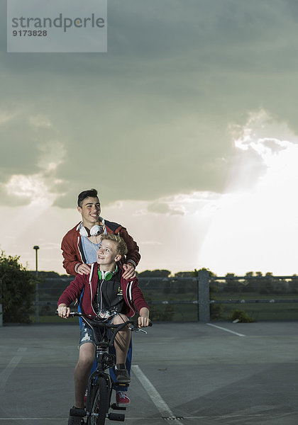 Zwei Jungs mit BMX-Bike und Kopfhörer