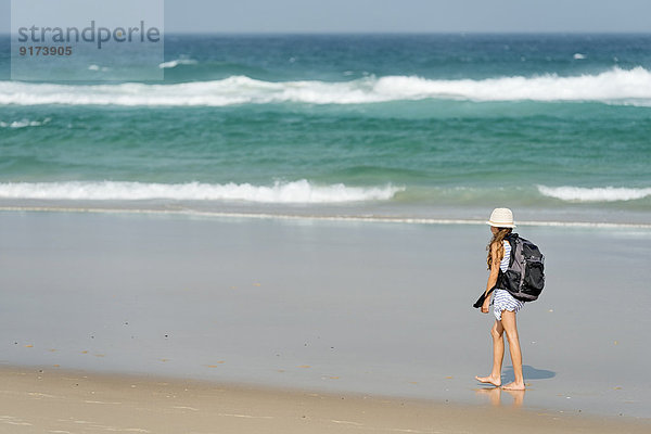Australien  New South Wales  Pottsville  Mädchen mit Rucksack auf dem Strand