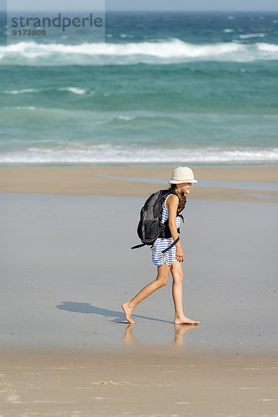 Australien  New South Wales  Pottsville  Mädchen mit Rucksack auf dem Strand