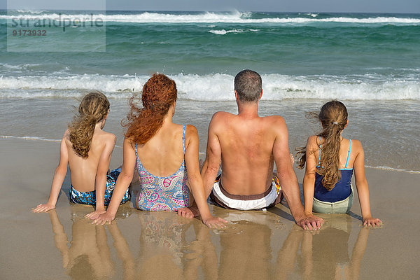 Australia  New South Wales  Pottsville  family sitting at the ocean