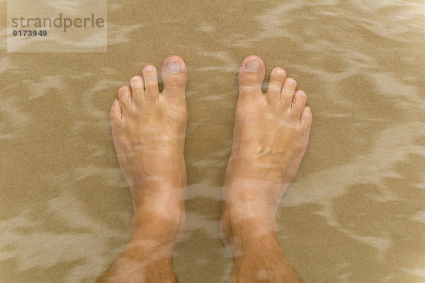 Australien  New South Wales  Pottsville  Doppelbelichtung männlicher Füße im Wasser