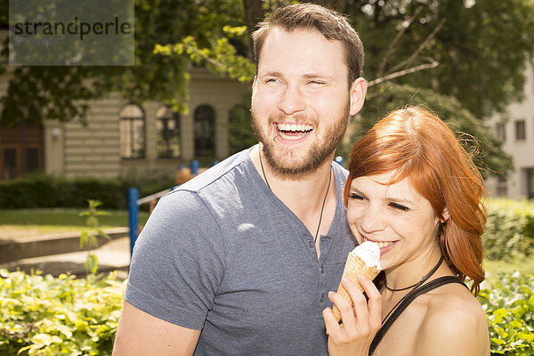 Deutschland  Bayern  München  Portrait eines glücklichen jungen Paares mit Eistüte