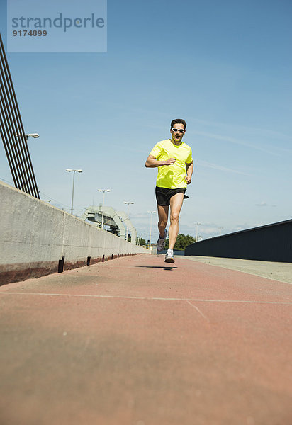 Mann joggt auf der Brücke