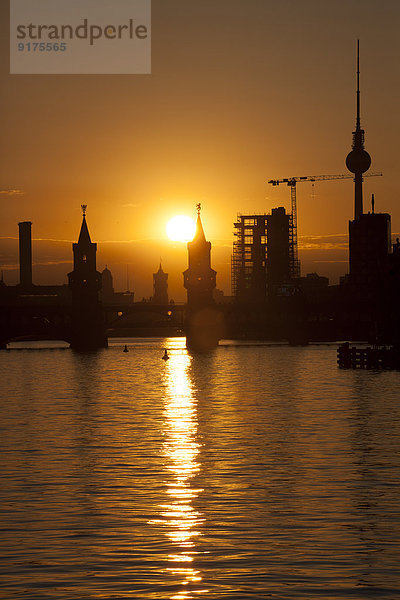 Deutschland  Berlin  Friedrichshain-Kreuzberg  Oberbaumbrücke und Spree  Berliner Fernsehturm im Hintergrund  bei Sonnenuntergang