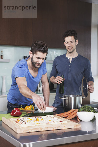 Porträt zweier Freunde beim gemeinsamen Kochen