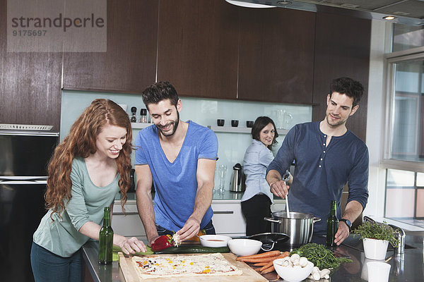 Porträt von vier Freunden beim gemeinsamen Kochen