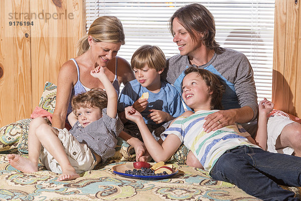 USA  Texas  Familie mit Obstschale auf dem Bett