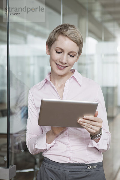 Deutschland  München  Geschäftsfrau im Büro  mit digitalem Tablett
