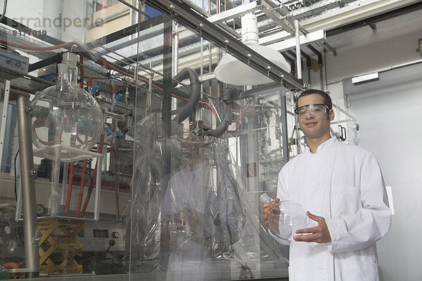 Porträt eines lächelnden Chemikers in einem Technikraum