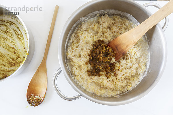 Topf mit gekochtem Reis und Mungobohnen mit Kräutern und gedünsteten Zwiebeln