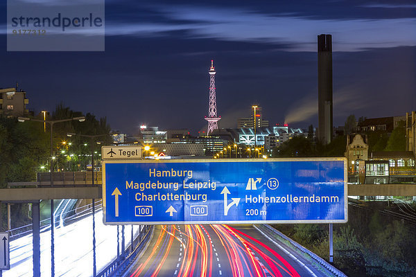 Deutschland  Berlin  Berlin  Berlin-Charlottenburg  Bundesautobahn 100 durch die Berliner Innenstadt mit dem Funkturm Berlin und den Messehallen im Hintergrund bei Nacht.