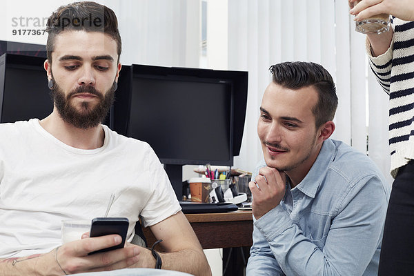 Zwei Männer im Büro mit Handy