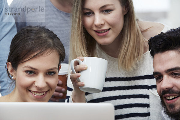 Gruppe von Kreativprofis mit Laptop am Tisch