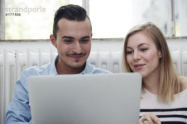Lächelnder Mann und Frau mit Laptop