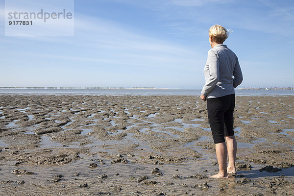 Deutschland  Niedersachsen  Nessmersiel  Frau beim Blick aufs Wattenmeer