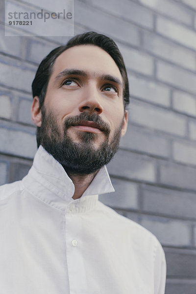 Porträt eines jungen bärtigen Mannes mit weißem Hemd