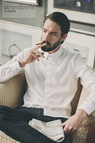 Porträt eines jungen Mannes  der Zigarillo raucht