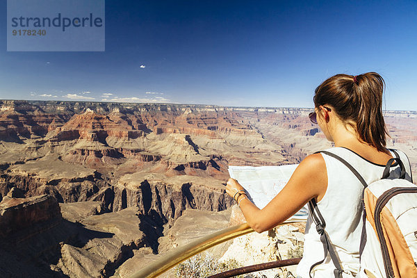 USA  Arizona  junge Frau mit Kartenausrichtung vor dem Grand Canyon
