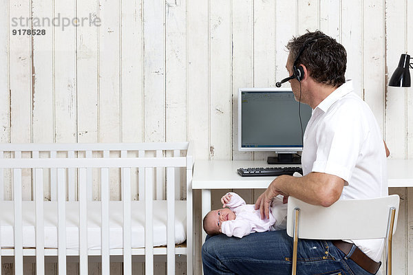 Mann im Home-Office mit seinem Baby