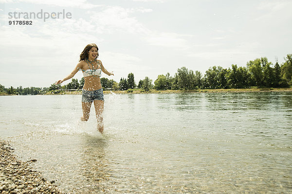 Junge Frau  die am Ufer des Rheins läuft