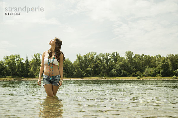 Junge Frau entspannt am Ufer des Rheins