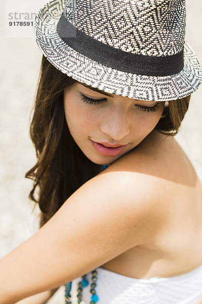Portrait einer jungen Frau mit Hut am Strand