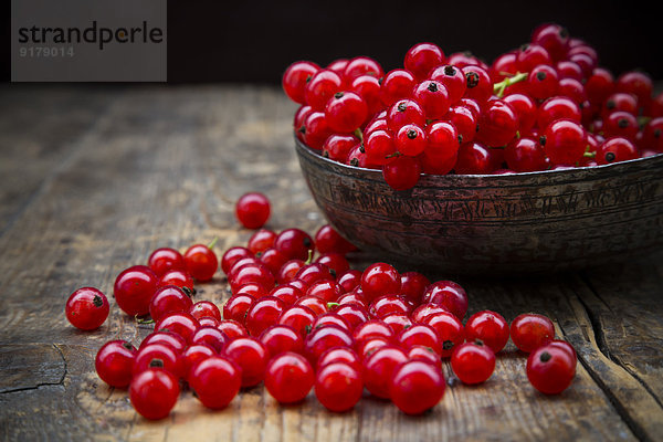 Schale mit roten Johannisbeeren  Ribes rubrum  auf dunklem Holztisch