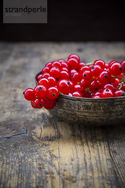 Schale mit roten Johannisbeeren  Ribes rubrum  auf dunklem Holztisch  Teilansicht
