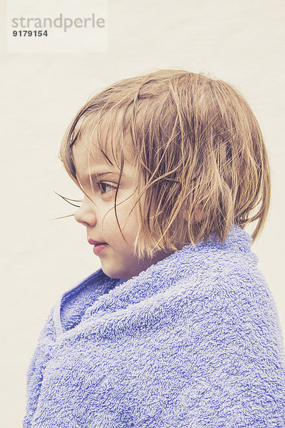 Profil eines kleinen Mädchens mit nassem Haar in ein Handtuch gewickelt