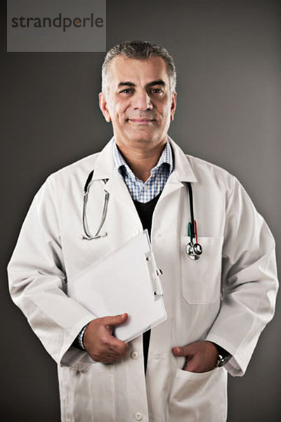 Portrait eines selbstbewussten Arztes mit Zwischenablage