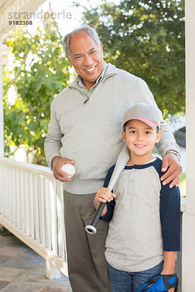 Portrait von Großvater und Enkel mit Baseball und Schläger