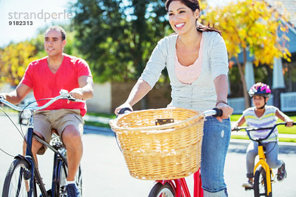 Fröhliches Familienradfahren auf der sonnigen Straße