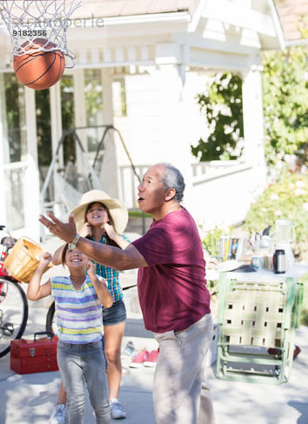 Großvater und Enkelinnen beim Basketballspielen